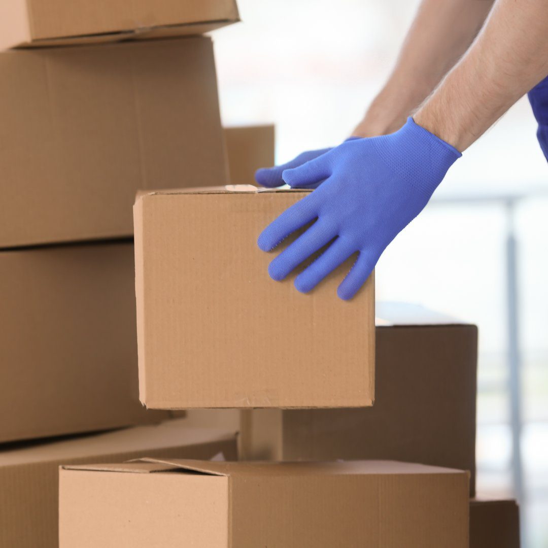 Delivery man moving boxes indoors Delivery man moving boxes